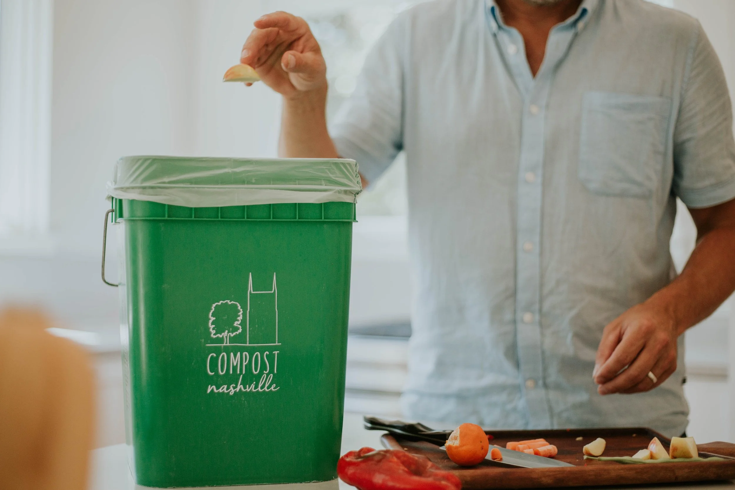 Tossing food scraps into a compost bin